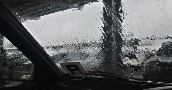 The inside of a car with a rainswept windshield