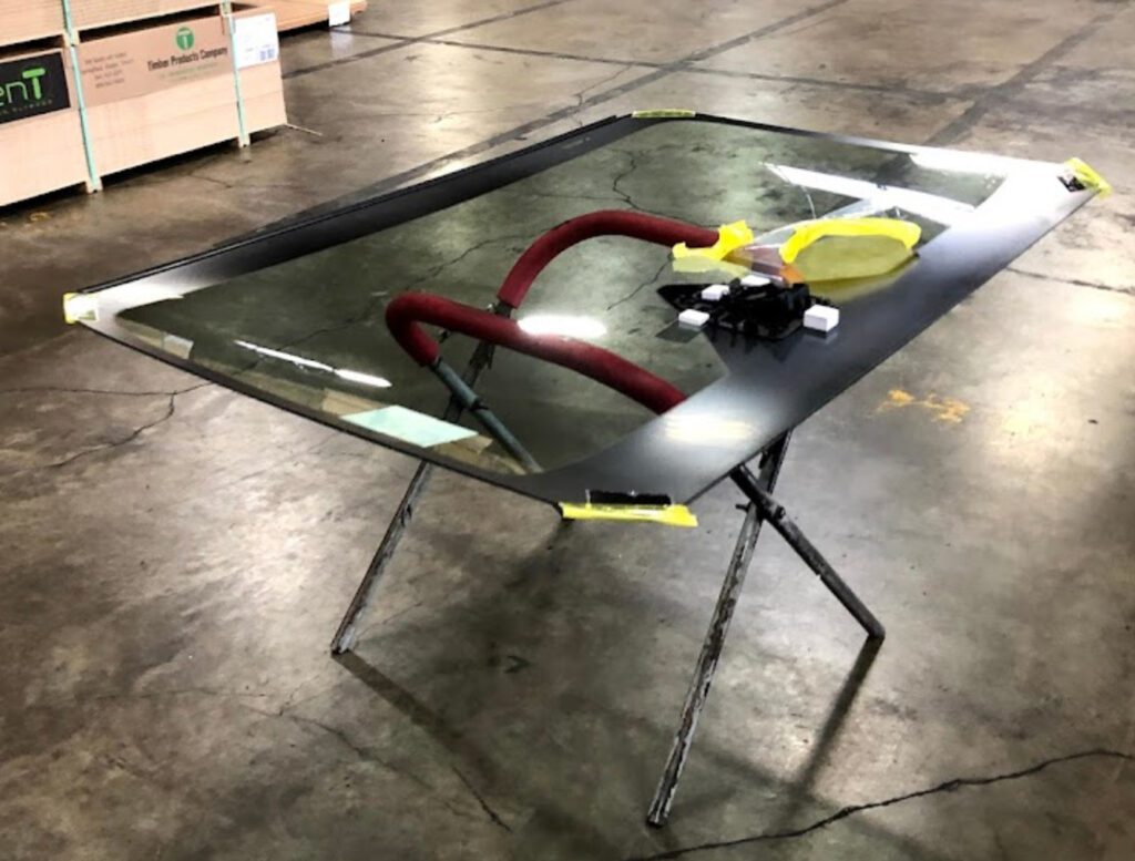 Image of a auto glass work bench with windshield